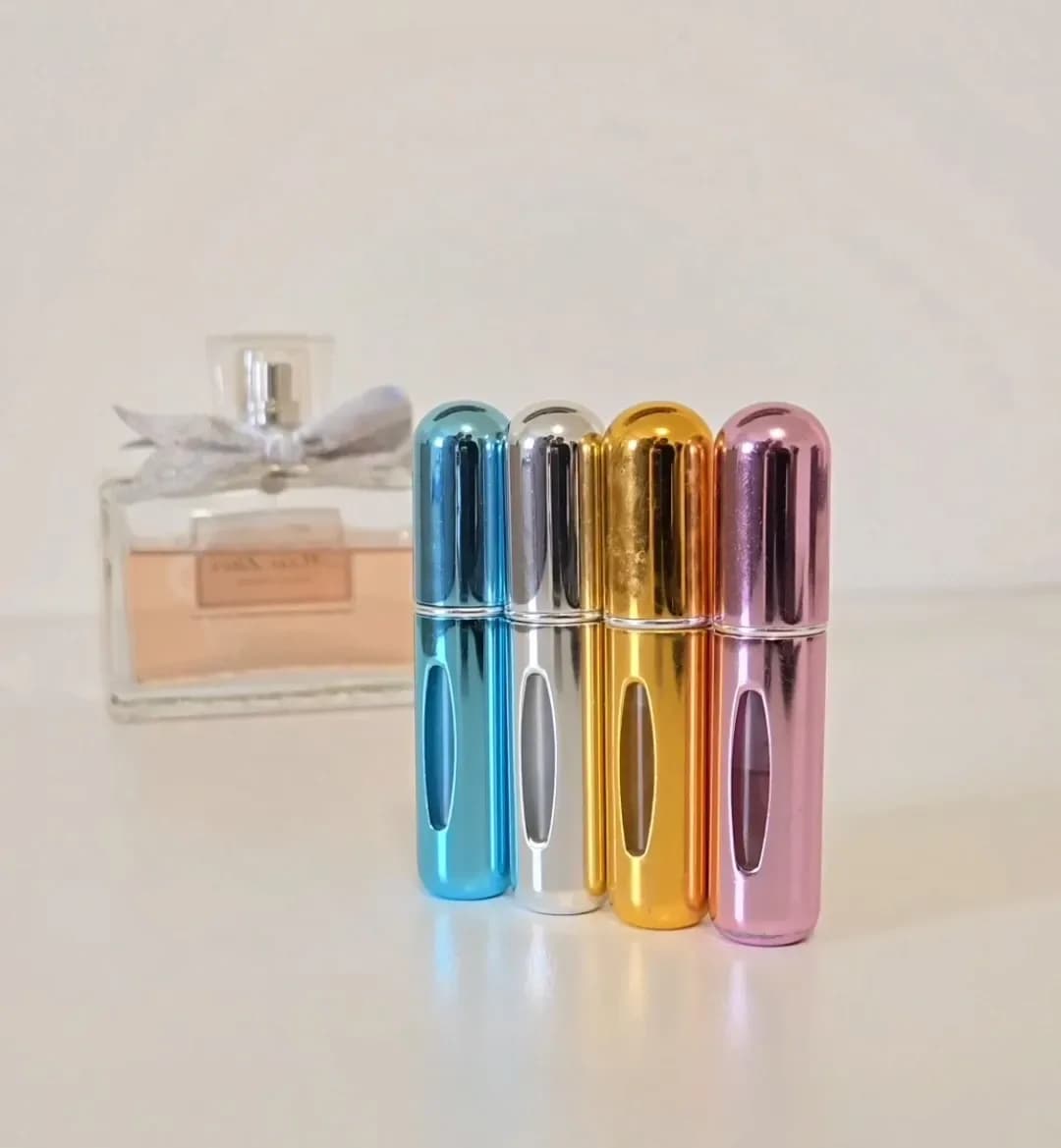 Refillable perfume atomizer shown in hand.